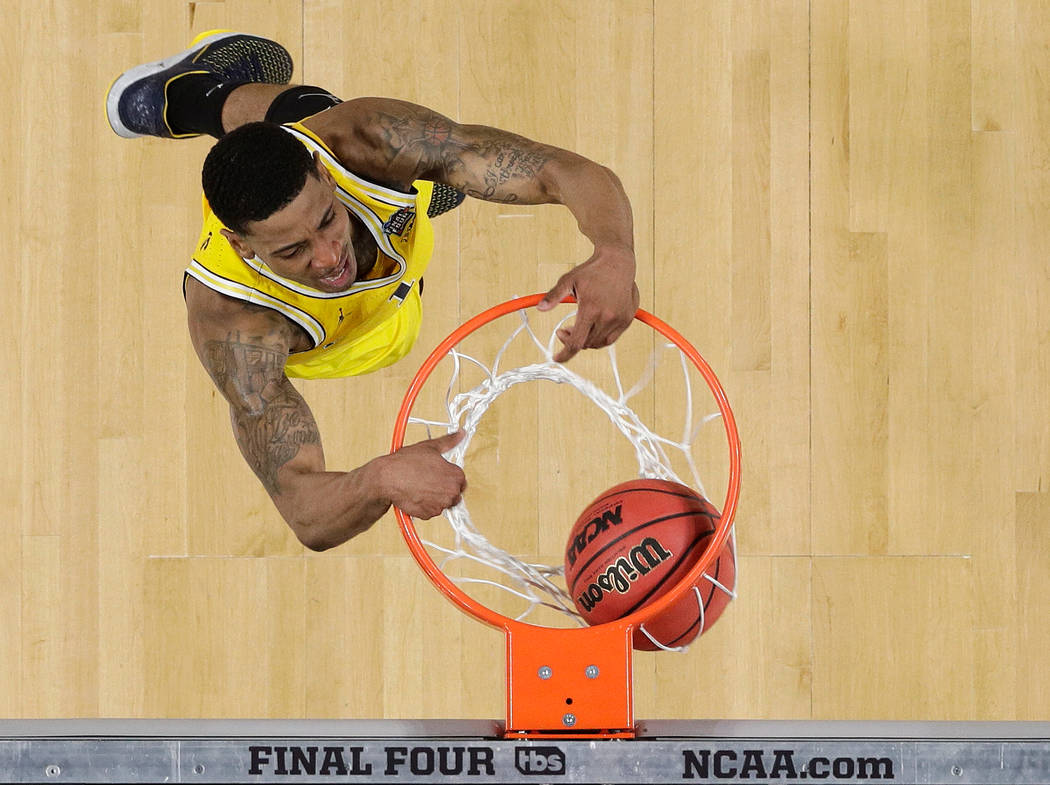 Michigan's Charles Matthews (1) dunks during the second half in the semifinals of the Final Four NCAA college basketball tournament against Loyola-Chicago, Saturday, March 31, 2018, in San Antonio ...