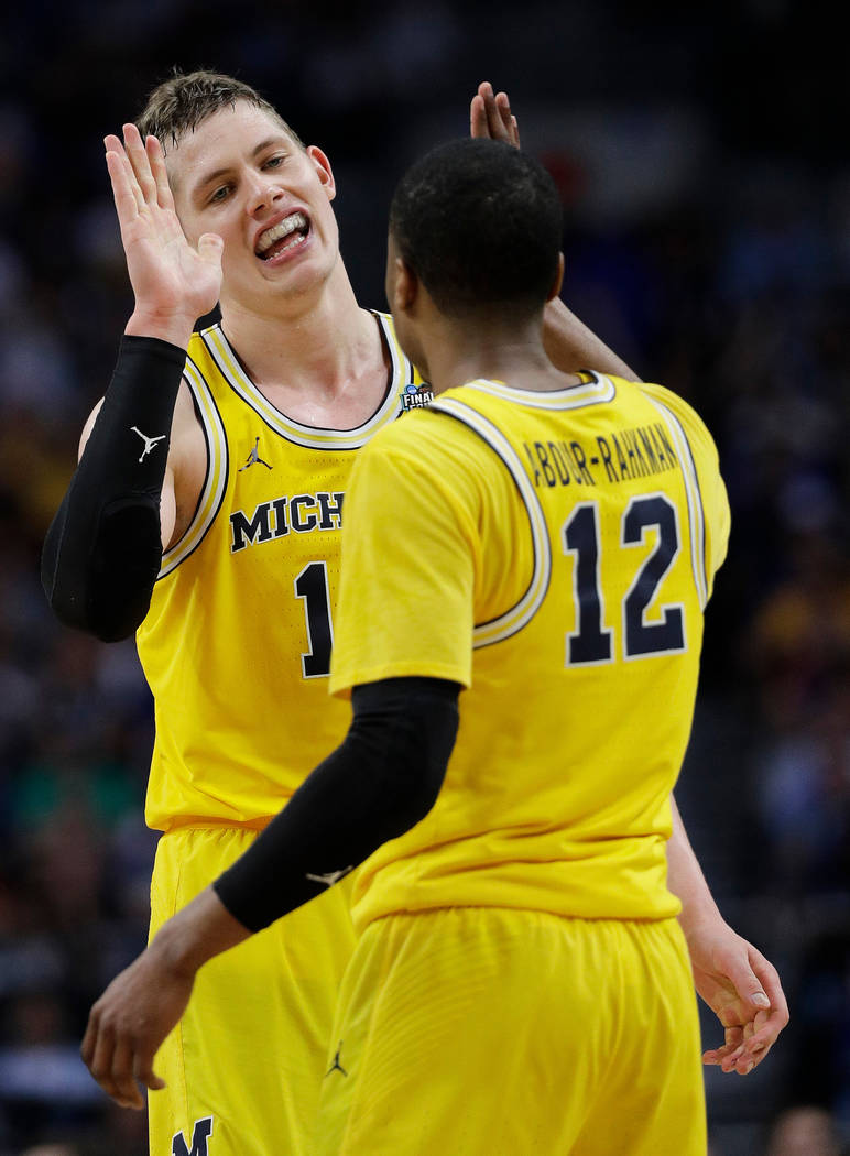 Michigan's Moritz Wagner celebrates with Muhammad-Ali Abdur-Rahkman (12) during the second half in the semifinals of the Final Four NCAA college basketball tournament against Loyola-Chicago, Satur ...
