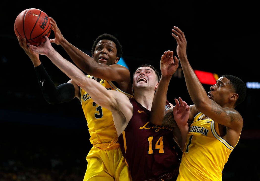 Loyola-Chicago guard Ben Richardson (14) fights for a rebound with Michigan guard Zavier Simpson, left, and Charles Matthews, right, during the second half in the semifinals of the Final Four NCAA ...