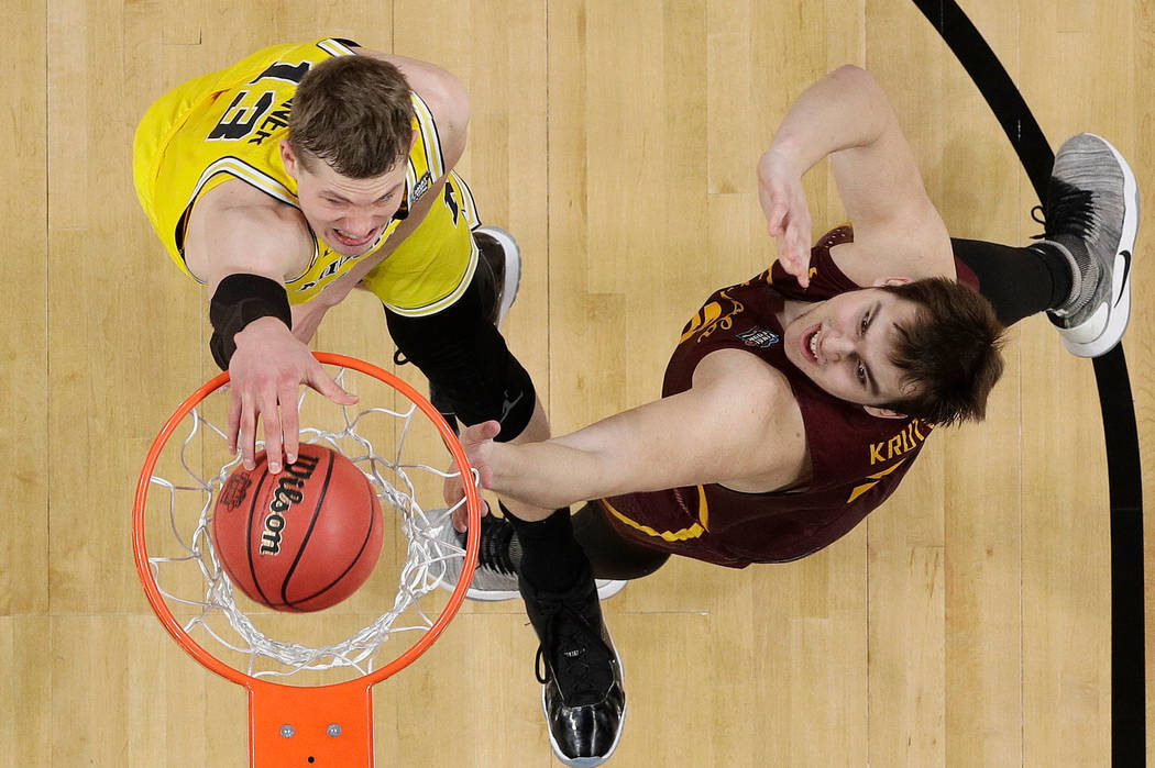 Michigan's Moritz Wagner (13) dunks over Loyola-Chicago's Cameron Krutwig (25) during the first half in the semifinals of the Final Four NCAA college basketball tournament, Saturday, March 31, 201 ...