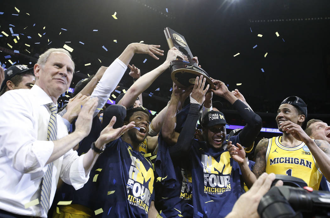 Michigan coach John Beilein, left, and players celebrate after the team's 58-54 win over Florida State in an NCAA men's college basketball tournament regional final Saturday, March 24, 2018, in Lo ...