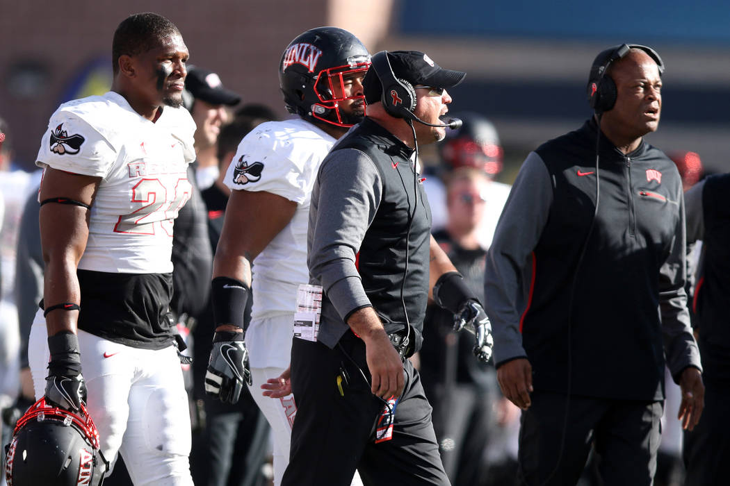 UNLV Rebels defensive line coach Tony Samuel, right, and head coach Tony Sanchez coach from the sideline as defensive back Greg Francis (23) looks on during the first half of their game in Reno, N ...
