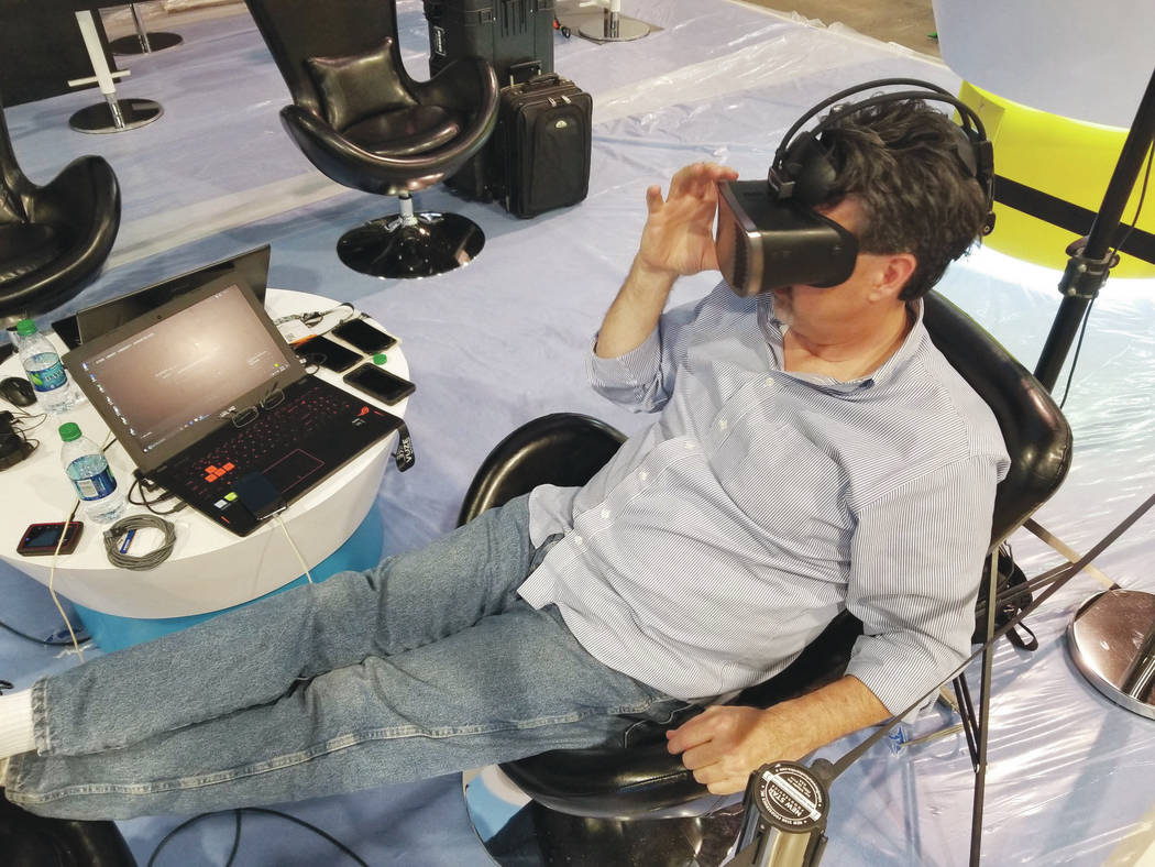 Jeff Miller, U.S. sales director for Israeli graphic arts company HumanEyes, adds video to a virtual reality headset at the Las Vegas Convention Center on Sunday, April 8, 2018. Miller will showca ...