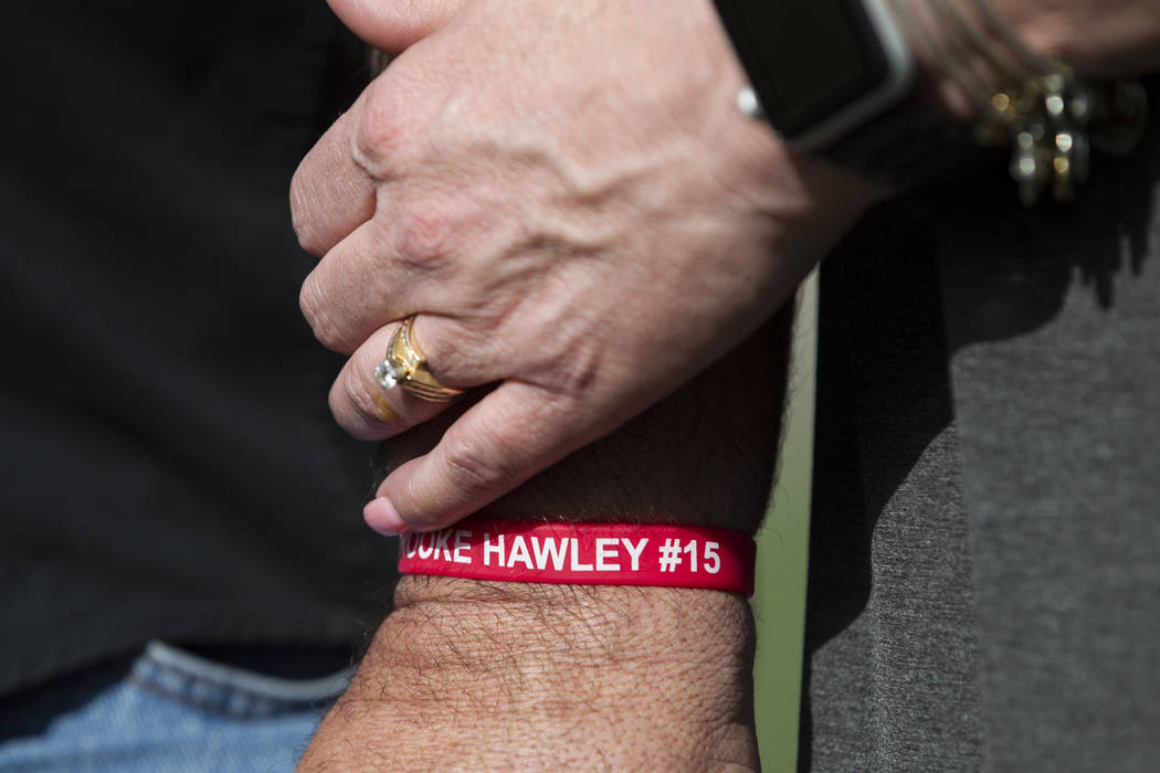 Aaron Hawley, wearing a wristband with the name of her daughter Brooke, holds hands with his wife Rhonda, during a press conference announcing the Brooke Hawley Memorial Scholarship, at the Bettye ...