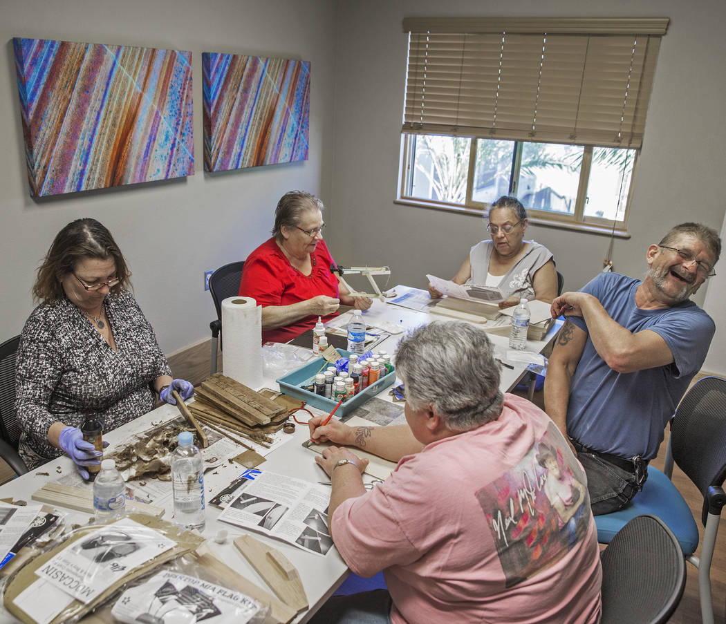 Clyda Byrd-Lopez, left, Carol Ambrose, Debbie Lara, William Bryant and Michele Marshall socialize while building shoe shine boxes on Tuesday, April 17, 2018, at Patriot Place Apartments, in Las Ve ...