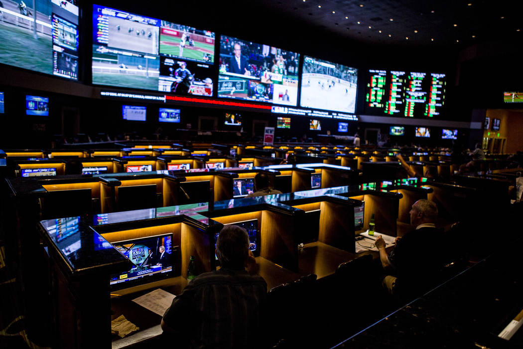 Sports betters watch games on individual screens as the the Golden Knights play the San Jose Sharks during the second round of the NHL playoffs at the Green Valley Ranch sports book in Henderson o ...