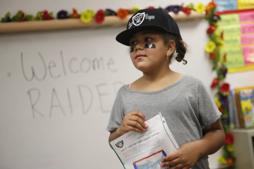 Jayda Mathis, 9, holds her drawing while watching Raiders players greet other students at Gene Ward elementary school in Las Vegas, Wednesday, May 9, 2018. Students participated in a raiders theme ...