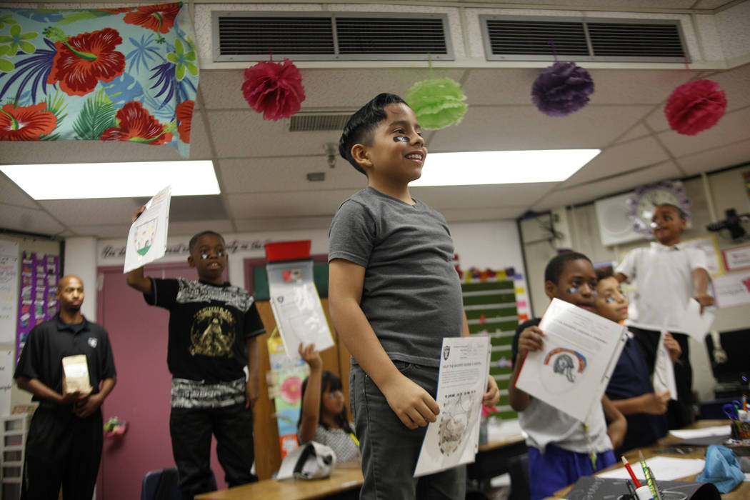 Marrail Parker-Briggs, 9, from left, Mauricio Garnica Mendez, 9, and Bryce Fortune, 8, wait with their drawings to show the Raiders players at Gene Ward elementary school in Las Vegas, Wednesday, ...