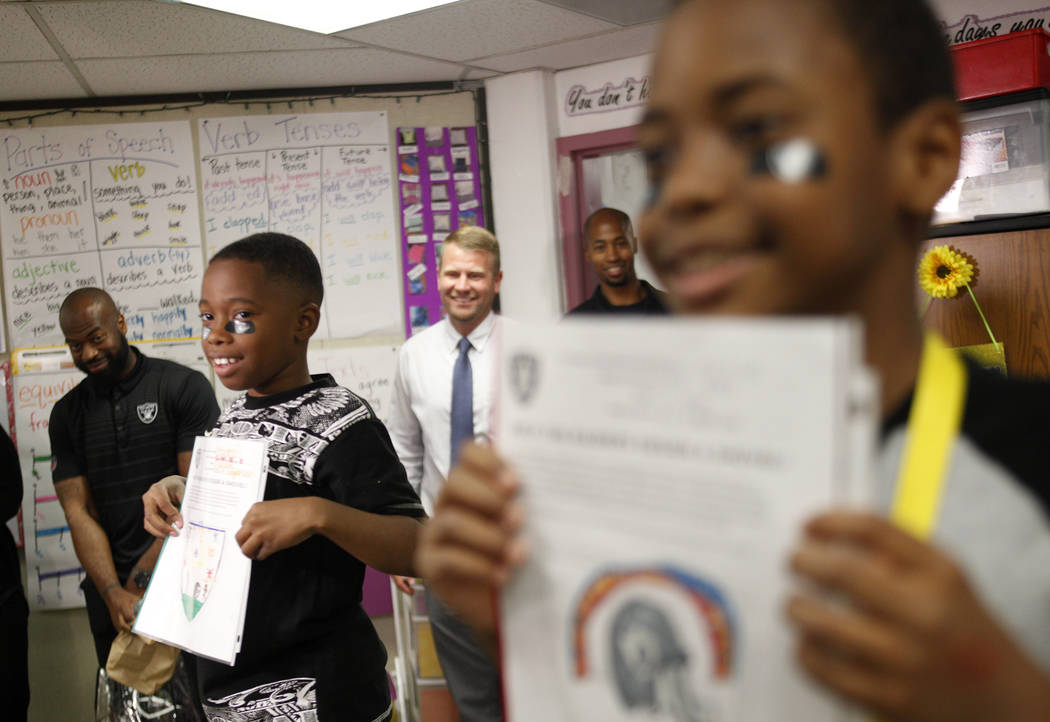 Marrail Parker-Briggs, 9, left, and Bryce Fortune, 8, right, wait with their drawings to show the Raiders players at Gene Ward elementary school in Las Vegas, Wednesday, May 9, 2018. Students part ...