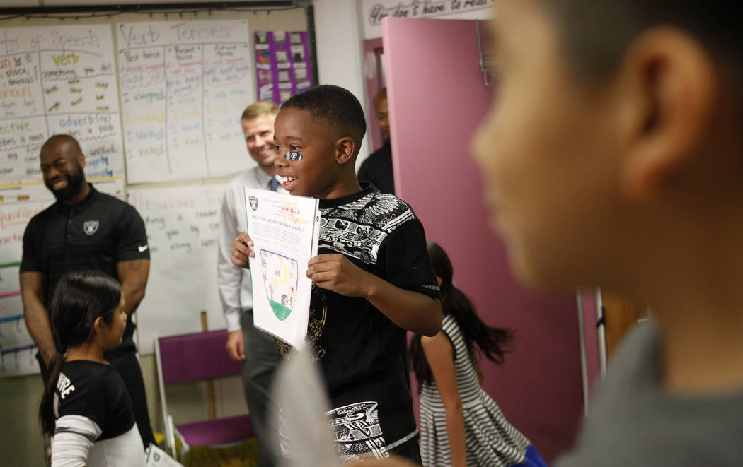 Marrail Parker-Briggs, 9, left, and Bryce Fortune, 8, right, hold their drawings to show the Raiders players at Gene Ward elementary school in Las Vegas, Wednesday, May 9, 2018. Students participa ...