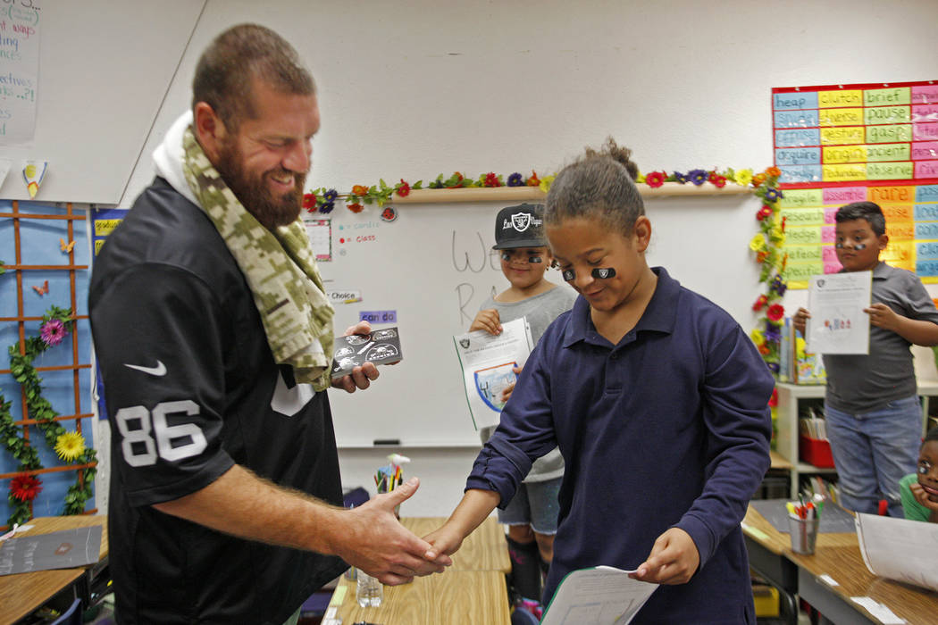 Oakland Raiders player Lee Smith talks to Royalty Edwards, 9, at Gene Ward elementary school in Las Vegas, Wednesday, May 9, 2018. Students participated in a raiders themed drawing contest. Rachel ...