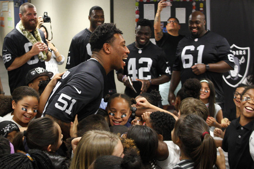 Oakland Raiders player Bruce Irvin huddles with students at Gene Ward elementary school in Las Vegas, Wednesday, May 9, 2018. Students participated in a raiders themed drawing contest. Rachel Asto ...