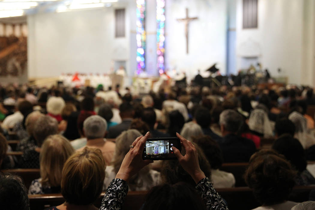 A woman takes a photos during the installation ceremony of Rev. George Leo Thomas as the third Bishop of Las Vegas, at The Shrine of the Most Holy Redeemer in Las Vegas, Tuesday, May 15, 2018. Eri ...