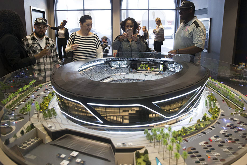 Kaipo Dean, from left, his sister Chianti Lloyd, mother Roxy Dean, and brother-in-law, Dewan Lloyd, view a Raiders stadium model on display at the Las Vegas stadium preview center at Town Square, ...
