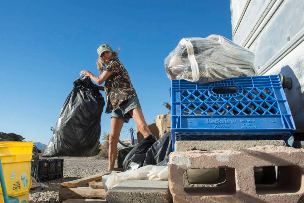Homeless resident Mary Supples packs up her belongings laying outside of her trailer in prepara ...
