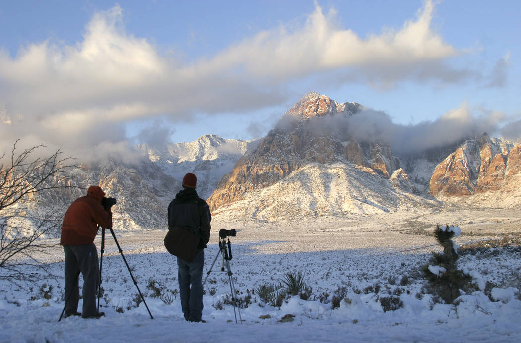 Photographers gather at the Red Rock Overlook on state Route 159 to capture images of the snow- ...