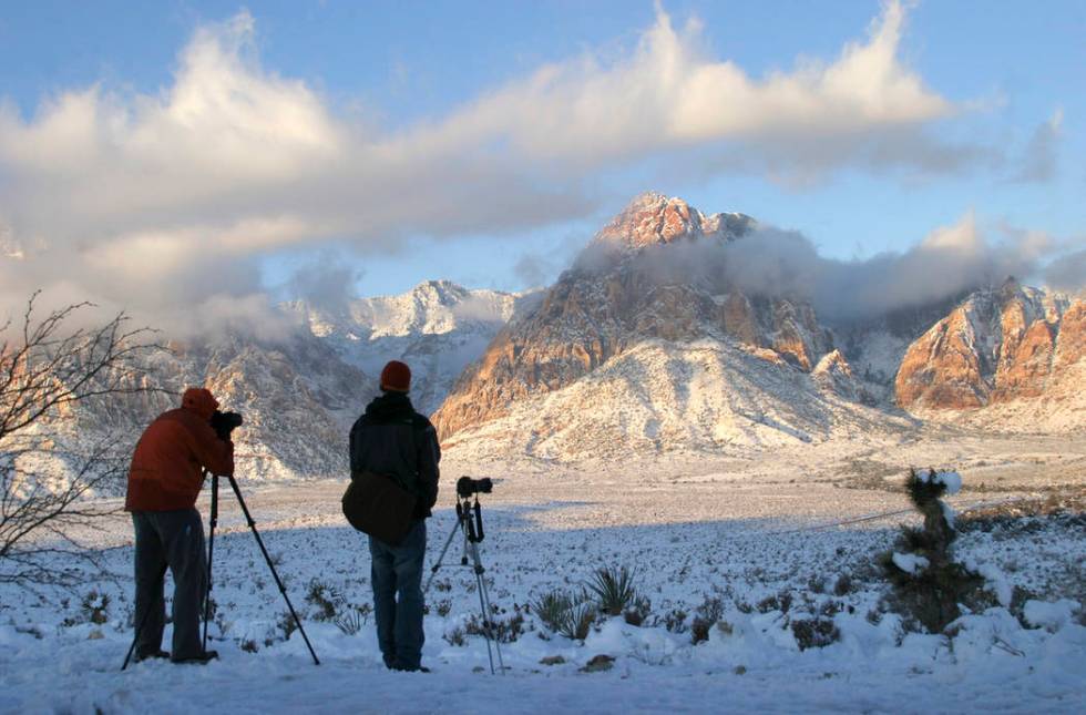 Photographers gather at the Red Rock Overlook on state Route 159 to capture images of the snow- ...