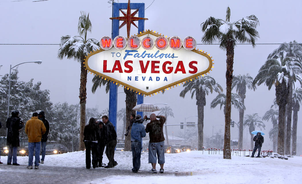 People visit the welcome sign on the Las Vegas Strip to take photos as snow fell in Las Vegas, ...