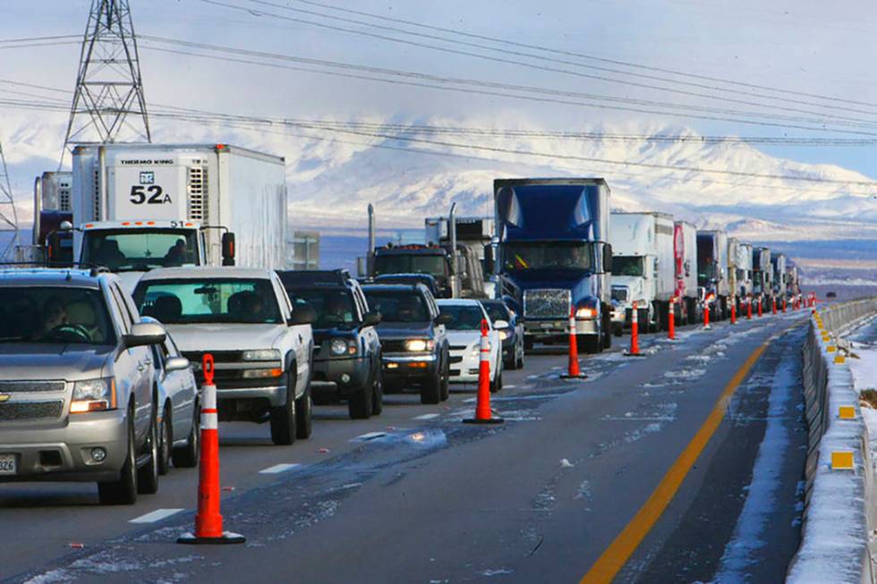 A line of semi tractor-trailers and other vehicles are parked on Interstate 15 in Primm on Dec. ...