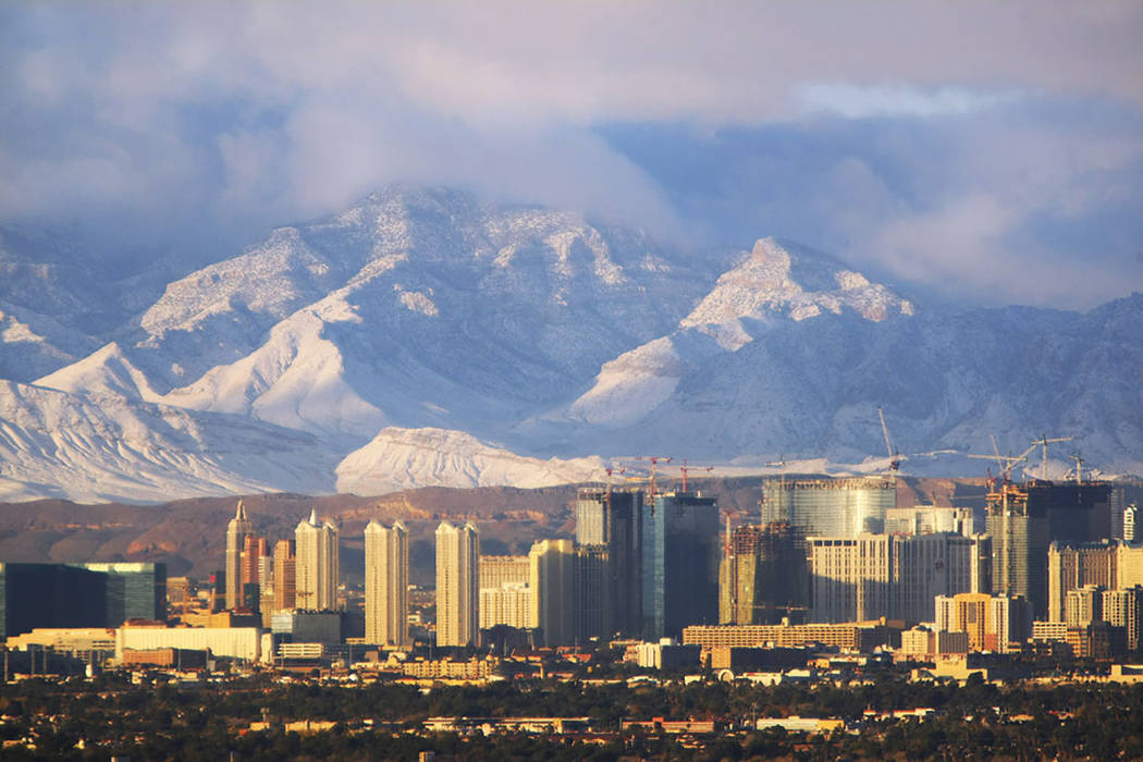 The morning sunlight gives a glow to the Las Vegas Strip and the snow-dusted Spring Mountains o ...