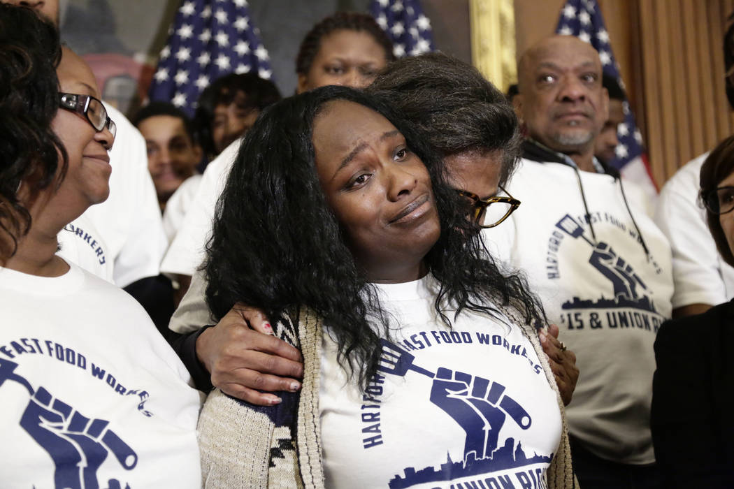 Tiffany Lowe, a fast food worker from Kansas City, is comforted by fellow union members after she gave an emotional speech in support of raising the minimum wage at an event with Speaker of the Ho ...