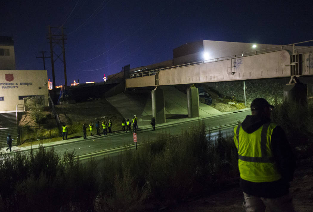 William Kight, right, looks around bushes for homeless people during the annual Southern Nevada ...