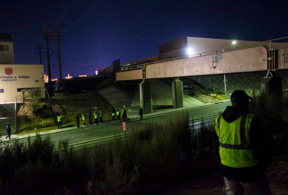 William Kight, right, looks around bushes for homeless people during the annual Southern Nevada ...