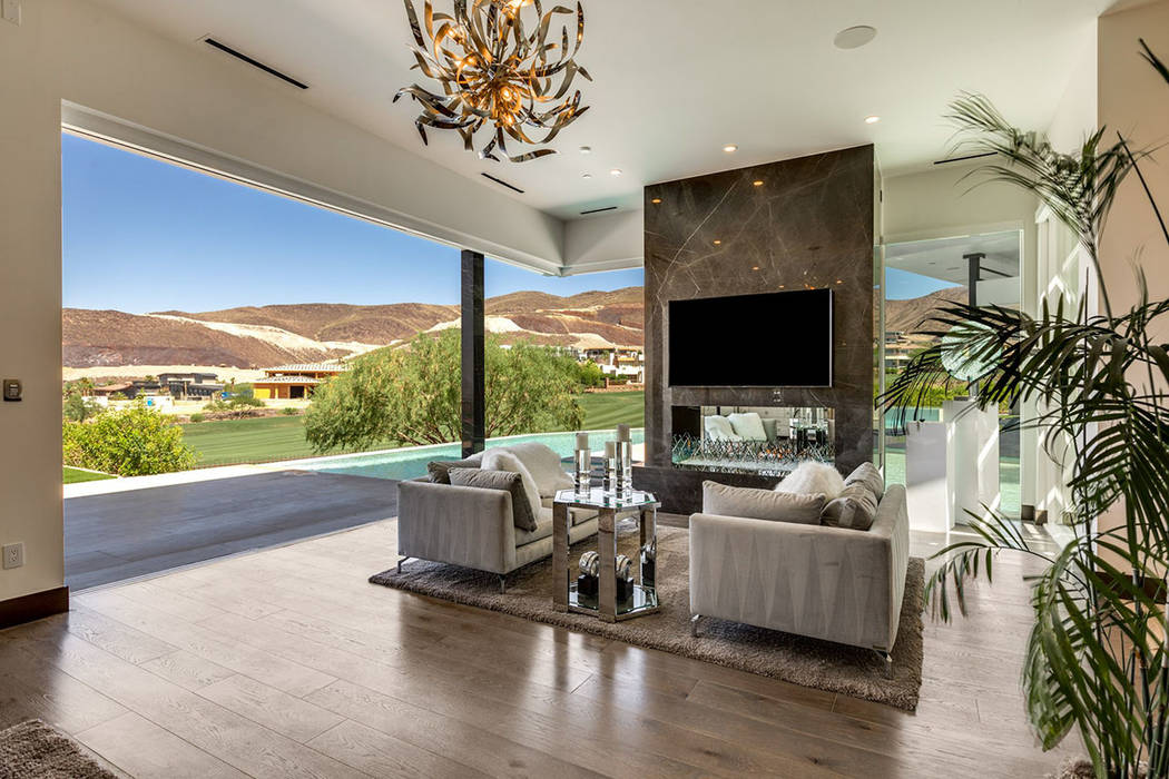 A sitting area with fireplace opens to the pool area. (Ivan Sher Group)
