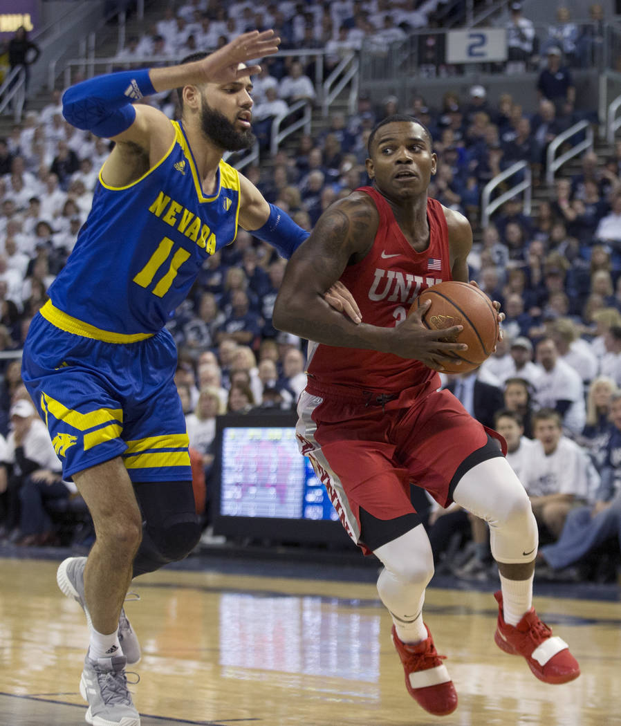 UNLV guard Amauri Hardy (3) drives the baseline against Nevada forward Cody Martin (11) during the first half of an NCAA college basketball game in Reno, Nev., Wednesday, Feb. 27, 2019. (AP Photo/ ...
