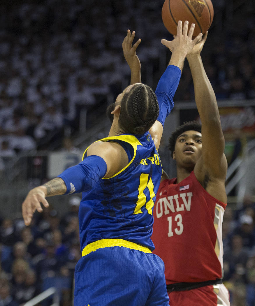 UNLV guard Bryce Hamilton (13) shoots over Nevada forward Cody Martin (11) during the first half of an NCAA college basketball game in Reno, Nev., Wednesday, Feb. 27, 2019. (AP Photo/Tom R. Smedes)