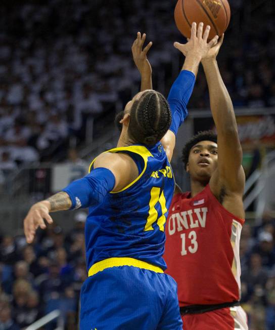 UNLV guard Bryce Hamilton (13) shoots over Nevada forward Cody Martin (11) during the first half of an NCAA college basketball game in Reno, Nev., Wednesday, Feb. 27, 2019. (AP Photo/Tom R. Smedes)