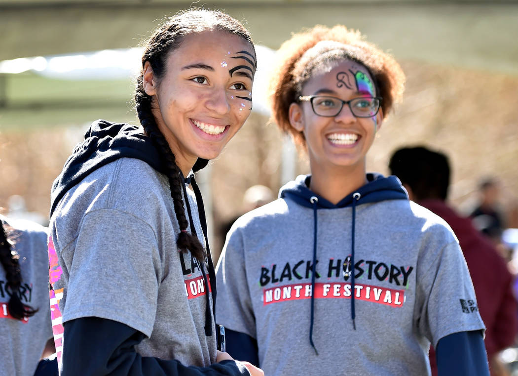 Volunteers Kennedy Enus, left, and Zia Makhathini watch a performance during the Black History ...