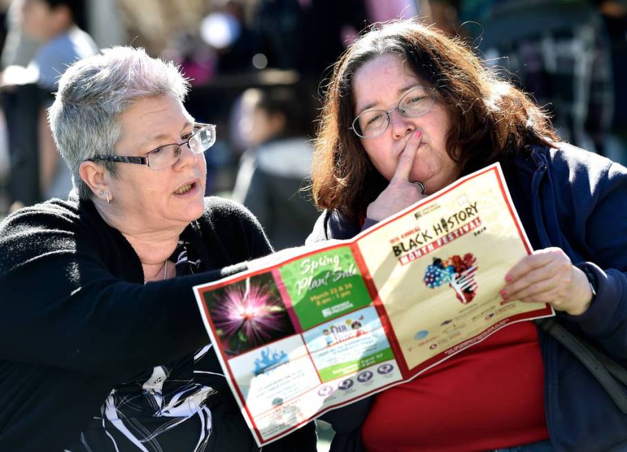 Marsha Rodenbeck, left, and Gina Slover review the event's program during the Black History Mon ...