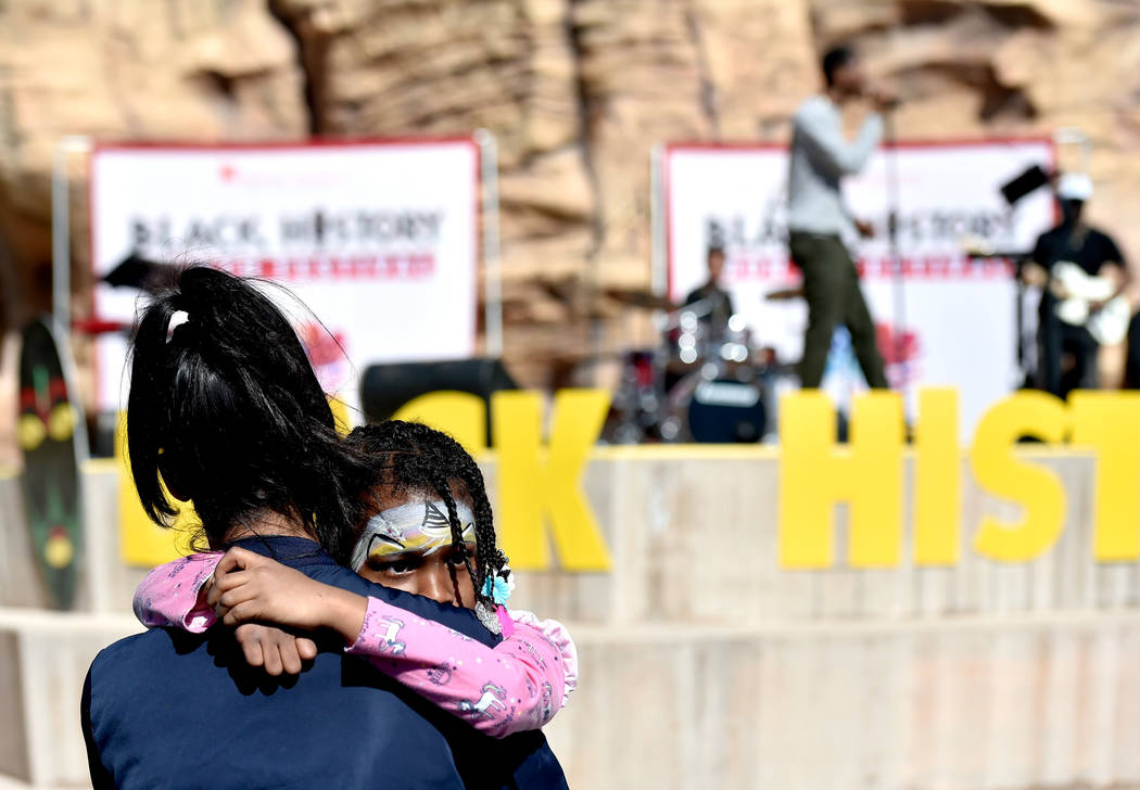 Israel Knight, 5, holds on to her mother, Victoria Knight during a performance at the Black His ...