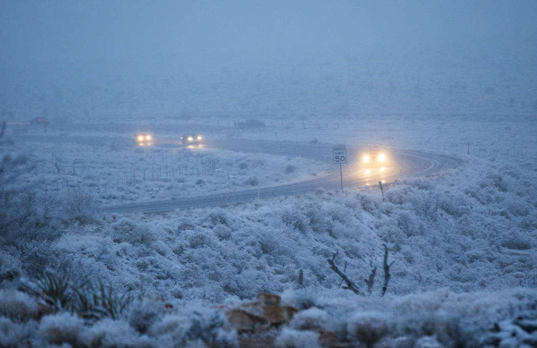 Vehicles drive along state Route 159 as snow falls around the Red Rock Canyon National Conservation Area outside of Las Vegas on Wednesday, Feb. 20, 2019. (Chase Stevens/Las Vegas Review-Journal) ...