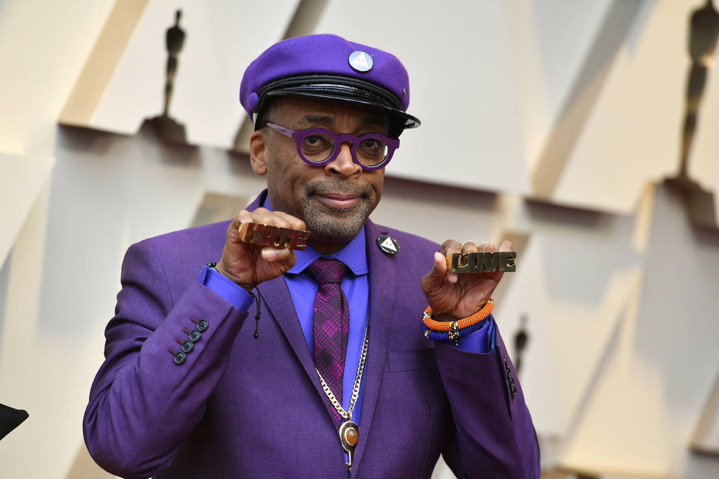 Spike Lee holds up brass knuckles reading "hate" and "love" from his iconic film "Do The Right Thing" as he arrives at the Oscars on Sunday, Feb. 24, 2019, at the Dol ...