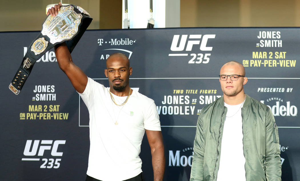 UFC light heavyweight champion Jon Jones raises his belt in the air as he stands next to his opponent, Anthony Smith at UFC 235 media day at the T-Mobile Arena in Las Vegas, Wednesday, Feb. 27, 20 ...