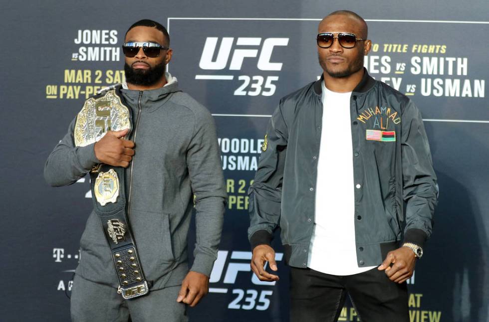 UFC welterweight champion Tyron Woodley, left, hoists his belt over his shoulder as he stands next to title challenger Kamaru Usman, right, during UFC 235 media day at the T-Mobile Arena in Las Ve ...