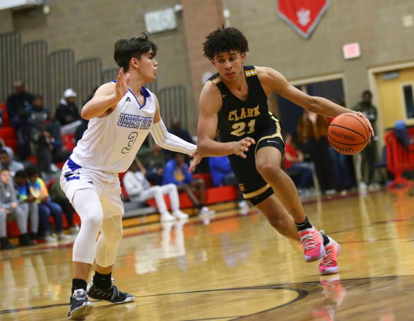 Clark's Jalen Hill (21) moves the ball around Desert Pines' Cimarron Conriquez (3) during the second half of a Class 4A state boys basketball quarterfinal game at Arbor View High School in Las Veg ...