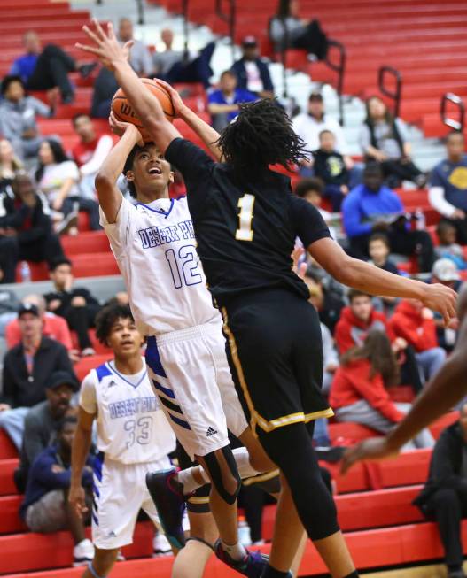 Desert Pines' Milos Uzan (12) shoots against Clark's Frankie Collins (1) during the first half of a Class 4A state boys basketball quarterfinal game at Arbor View High School in Las Vegas on Wedne ...