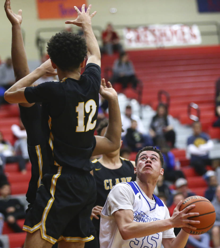 Desert Pines' Roland Gates (35) looks to shoot past Clark's Cameron Kimble (12) during the first half of a Class 4A state boys basketball quarterfinal game at Arbor View High School in Las Vegas o ...