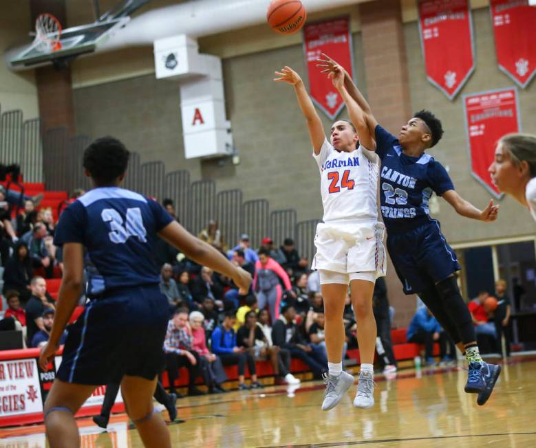 Bishop Gorman's Bentleigh Hoskins (24) shoots under pressure from Canyon Springs' Kayla Johnson (23) during the first half of a Class 4A state girls basketball quarterfinal game at Arbor View High ...