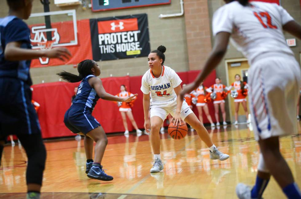 Bishop Gorman's Bentleigh Hoskins (24) moves the ball around Canyon Springs' Rajah Thomas (2) during the first half of a Class 4A state girls basketball quarterfinal game at Arbor View High School ...
