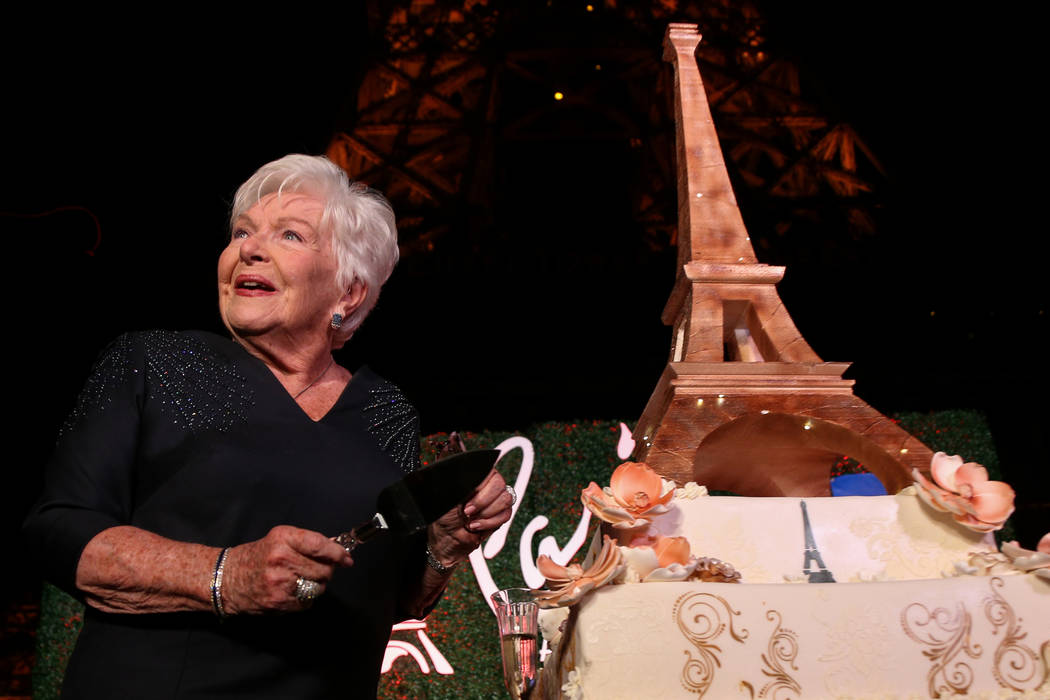 French singer and actress Line Renaud gets ready to cut an Eiffel Tower shaped cake as the Paris Las Vegas debuts a new $1.7 million Eiffel Tower light show on the Strip in Las Vegas, Wednesday, F ...