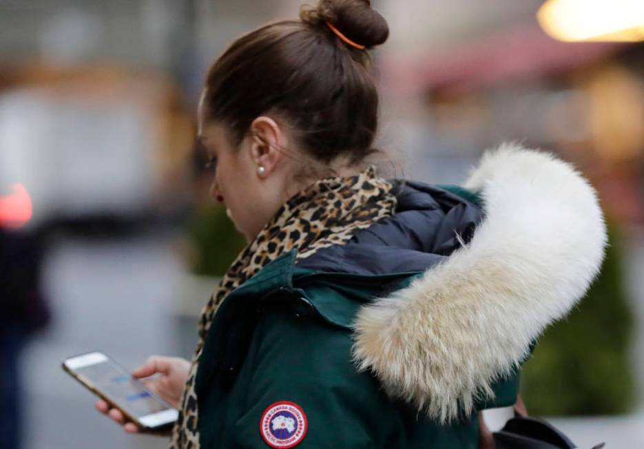 In this Feb. 14, 2019 photo, a woman in New York wears a Canada Goose coat with the hood trimmed in coyote fur. The fur-trimmed parkas so common on city sidewalks have become a boon to backwoods ...