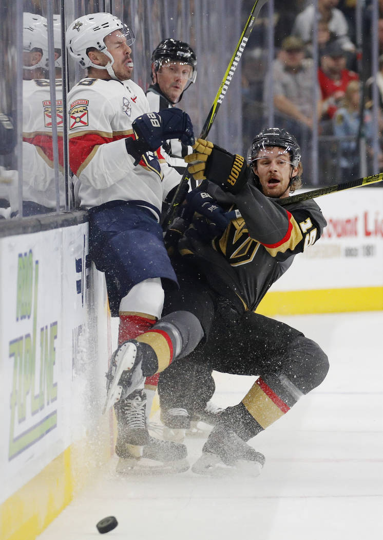 Vegas Golden Knights defenseman Jon Merrill (15) checks Florida Panthers center Jayce Hawryluk (8) into the boards during the first period of an NHL hockey game Thursday, Feb. 28, 2019, in Las Veg ...