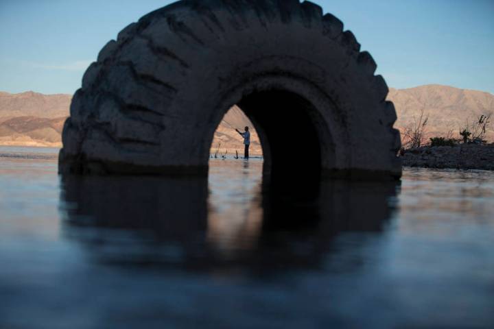 Ivan Lau of Las Vegas is seen through a partially submerged tire as he fishes near Boulder Harbor at Lake Mead National Recreation Area on Wednesday, Sept. 26, 2018. Richard Brian Las Vegas Review ...