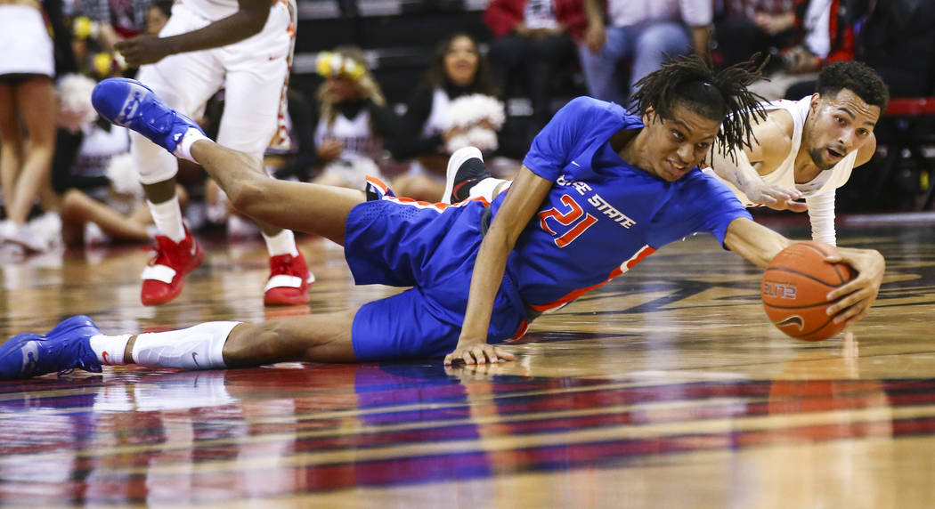 Boise State Broncos guard Derrick Alston (21) and UNLV Rebels guard Noah Robotham battle for a loose ball during the second half of a basketball game at the Thomas & Mack Center in Las Vegas o ...