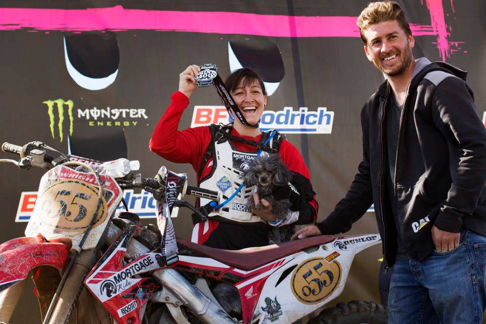 Angie Wright holds her medal next to her boyfriend Derek Stephens and her dog Phoenix after completing the Mint 400 motorcycle race in Primm, Nevada, Saturday, March 9, 2019. She completed in the ...