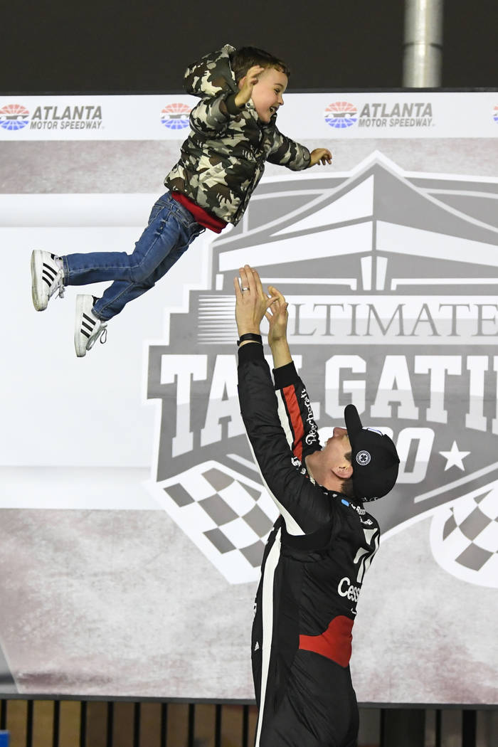 Kyle Busch tosses his son Brexton up in the air while celebrating in Victory Lane after winning the NASCAR Truck Series auto race at Atlanta Motor Speedway, Saturday, Feb. 23, 2019, in Hampton, Ga ...